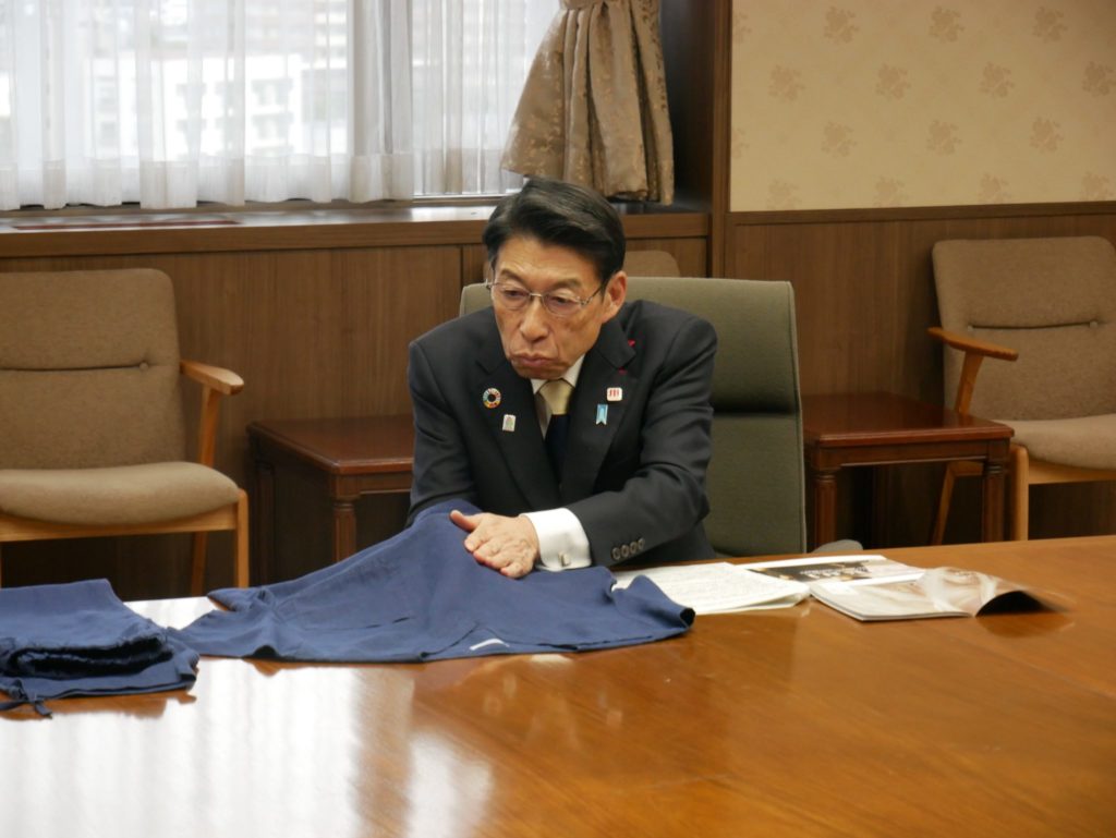サステナブル医療ウェア「sukui」の手触りと品質を確認する福岡県 服部誠太郎知事。